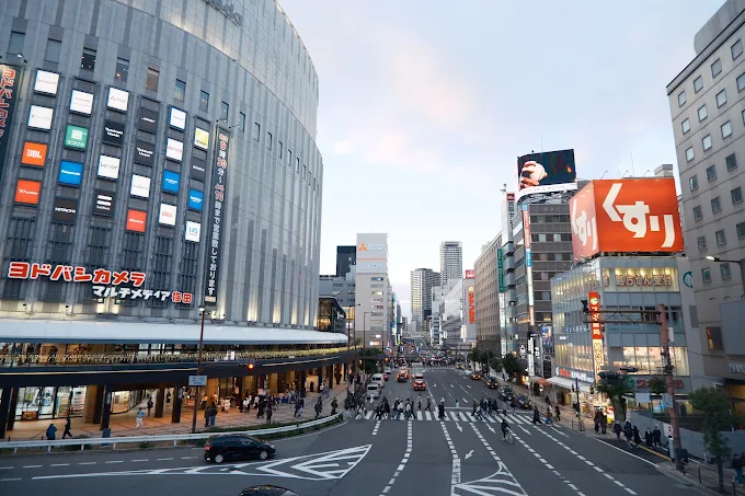 Osaka city crossing with bright billboards at dusk